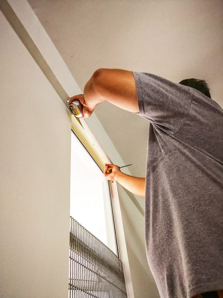 Man measure and install curtain panel at the window. do it yourself, diy, man at work.