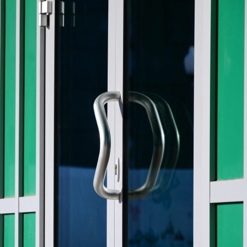 chrome-door-handle-and-glass-of-modern-aluminium-door-outside-the-office-building
